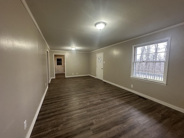 spare room featuring crown molding and dark hardwood / wood-style flooring