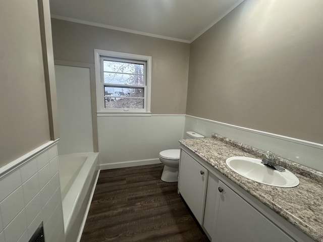 bathroom with toilet, ornamental molding, vanity, a bath, and hardwood / wood-style flooring