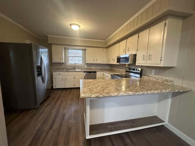 kitchen with ornamental molding, stainless steel appliances, kitchen peninsula, and sink