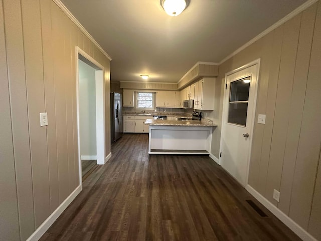 kitchen with ornamental molding, kitchen peninsula, white cabinets, and appliances with stainless steel finishes