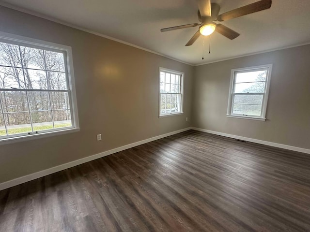 spare room with crown molding, a healthy amount of sunlight, and dark hardwood / wood-style floors