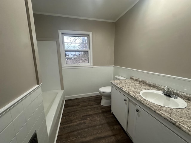 bathroom with toilet, crown molding, vanity, a bathing tub, and hardwood / wood-style flooring