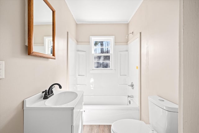 bathroom with crown molding, toilet, washtub / shower combination, vanity, and wood finished floors