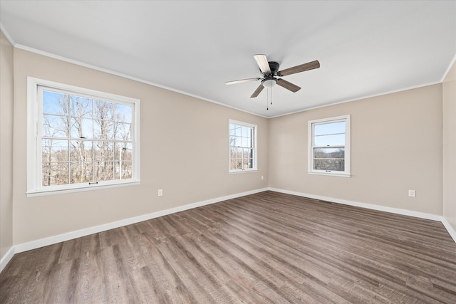 spare room with a ceiling fan, baseboards, crown molding, and wood finished floors