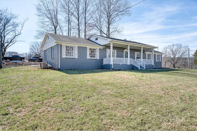 view of front facade with covered porch, brick siding, and a front yard