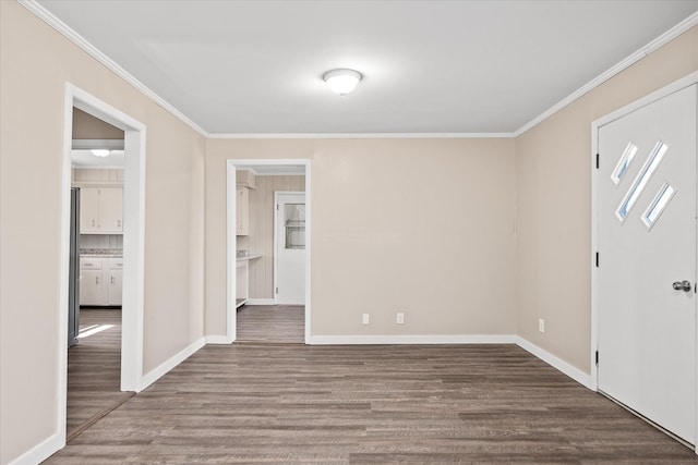 empty room with baseboards, ornamental molding, and wood finished floors