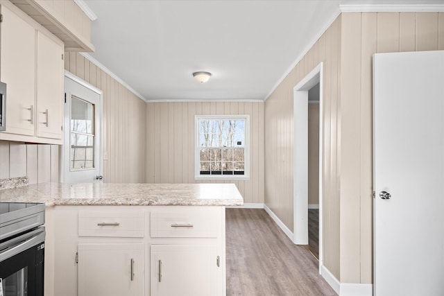 kitchen with light wood finished floors, stainless steel electric range oven, a peninsula, crown molding, and white cabinetry