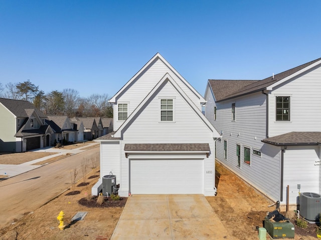 view of front of property with a garage and central air condition unit