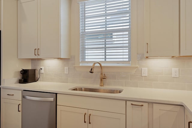 kitchen featuring white cabinetry, stainless steel dishwasher, sink, and decorative backsplash