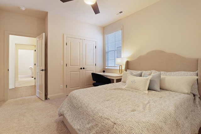 carpeted bedroom with ceiling fan and a closet