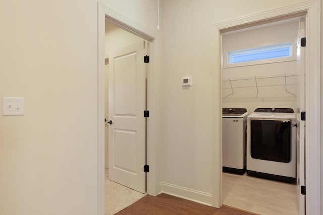 washroom featuring light hardwood / wood-style flooring and washing machine and clothes dryer