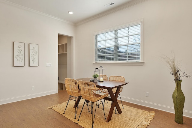 dining space featuring crown molding and hardwood / wood-style floors