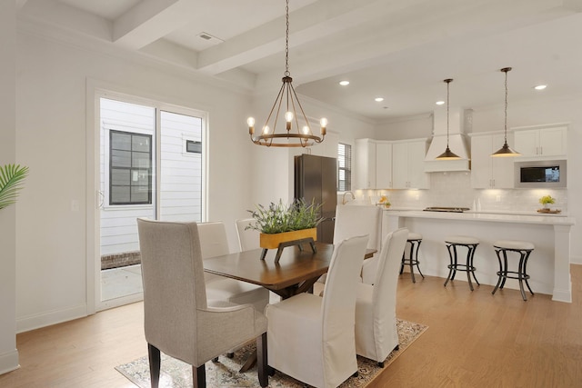 dining room featuring an inviting chandelier, light hardwood / wood-style flooring, and beam ceiling