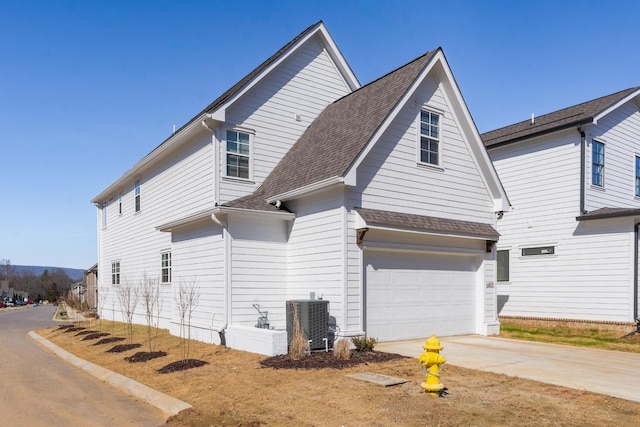 view of side of property featuring a garage and cooling unit