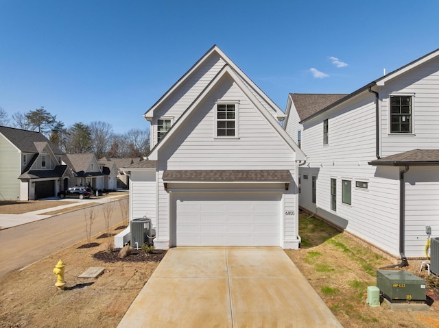 view of property featuring a garage and central AC