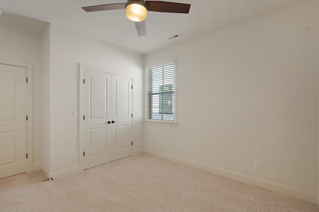 unfurnished bedroom with ceiling fan, a closet, and light colored carpet