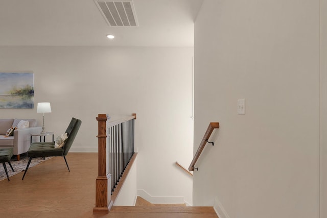 staircase with hardwood / wood-style floors