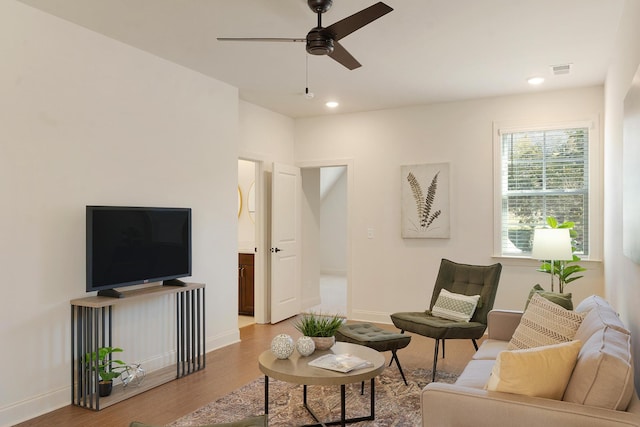 living room featuring ceiling fan and light hardwood / wood-style flooring