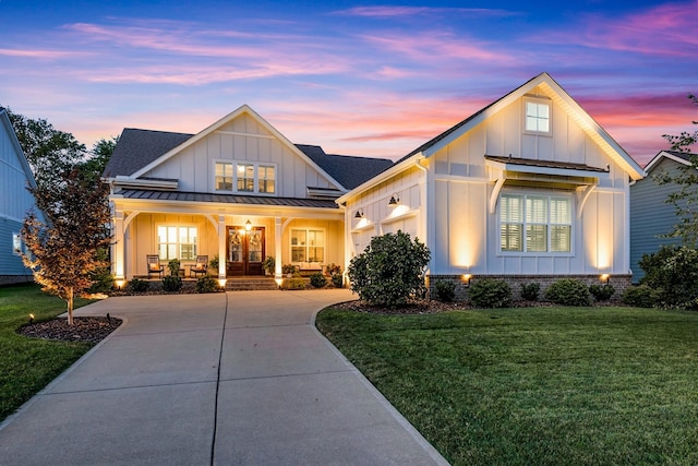 view of front facade featuring a garage, a yard, and a porch