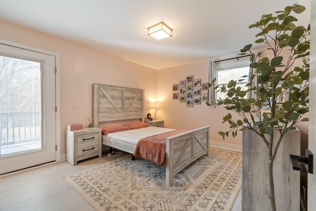 bedroom featuring access to exterior and light hardwood / wood-style flooring