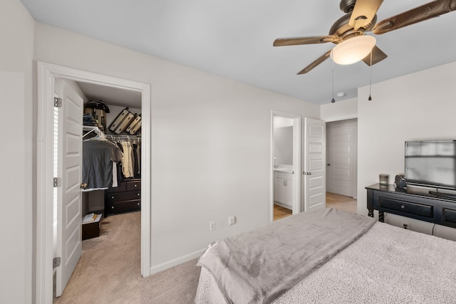 carpeted bedroom with connected bathroom, a spacious closet, a closet, and ceiling fan