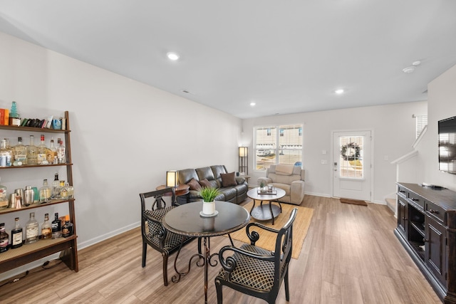 dining room featuring bar and light hardwood / wood-style flooring