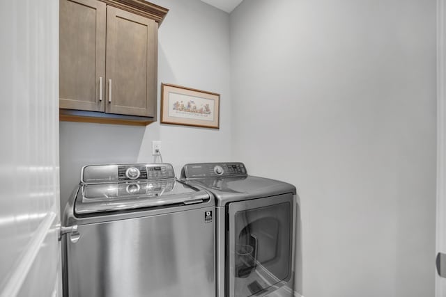 washroom featuring cabinets and washing machine and dryer