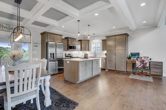 kitchen with appliances with stainless steel finishes, sink, hanging light fixtures, and a wealth of natural light