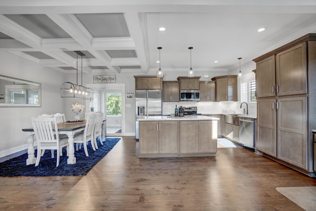 kitchen featuring pendant lighting, stainless steel appliances, beam ceiling, and a kitchen island