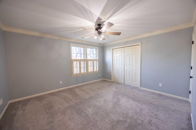 unfurnished bedroom with crown molding, ceiling fan, carpet, and a closet