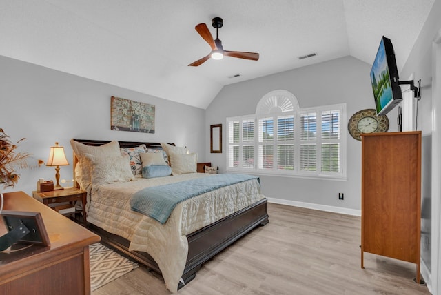 bedroom with ceiling fan, vaulted ceiling, and light wood-type flooring