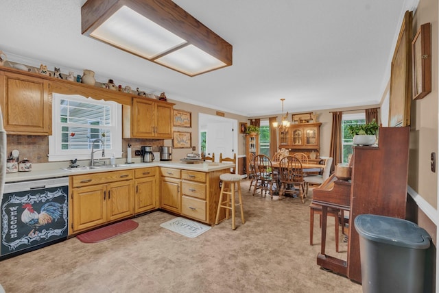 kitchen with decorative light fixtures, sink, dishwashing machine, kitchen peninsula, and crown molding