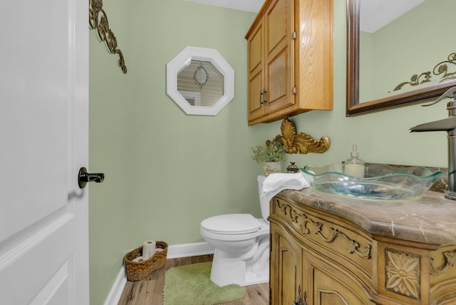 bathroom with hardwood / wood-style flooring, vanity, and toilet