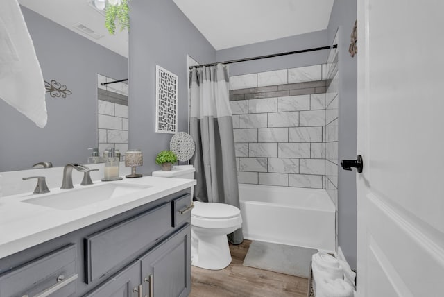 full bathroom featuring vanity, wood-type flooring, shower / bath combination with curtain, and toilet