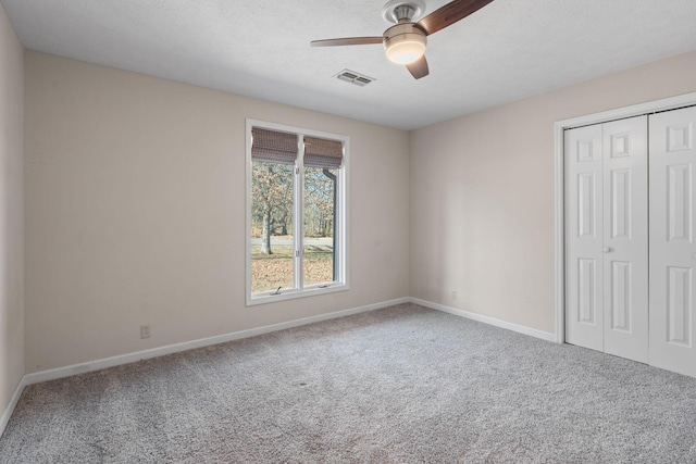 unfurnished bedroom featuring carpet, ceiling fan, and a closet