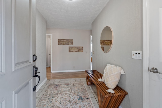 foyer entrance with light tile patterned floors and a textured ceiling