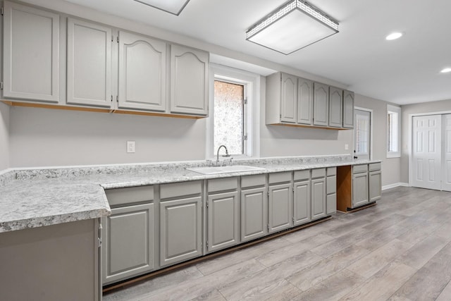 kitchen featuring gray cabinetry, sink, a wealth of natural light, and light hardwood / wood-style flooring