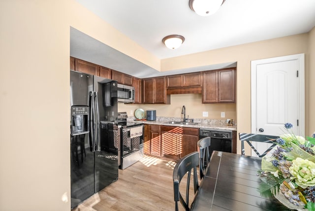 kitchen featuring sink, black appliances, and light wood-type flooring