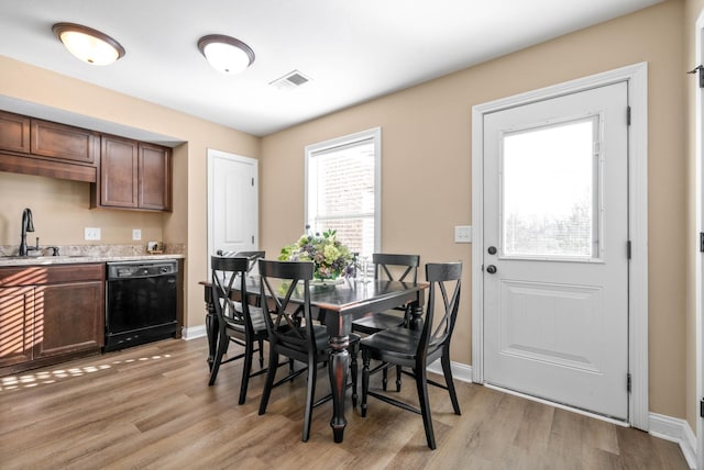 dining room with light hardwood / wood-style floors and sink