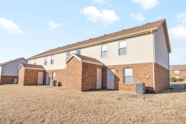 rear view of house featuring a lawn, a patio area, and central air condition unit