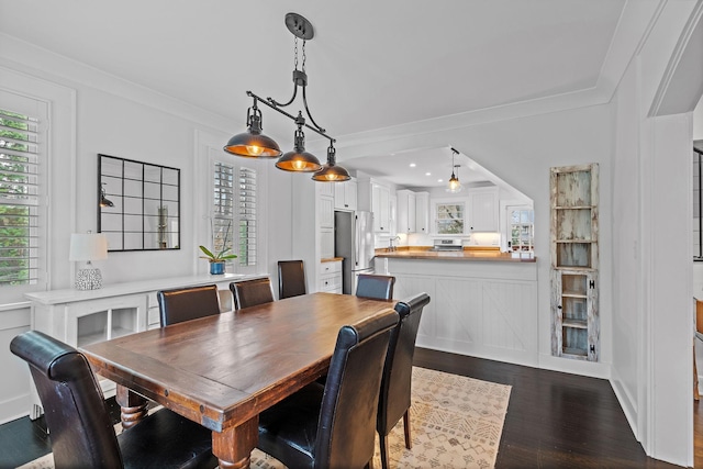 dining area featuring ornamental molding and dark hardwood / wood-style flooring