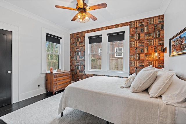 bedroom with ornamental molding, dark hardwood / wood-style floors, and ceiling fan