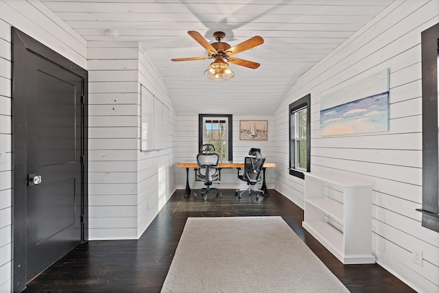 office space featuring dark hardwood / wood-style flooring, vaulted ceiling, and wooden walls