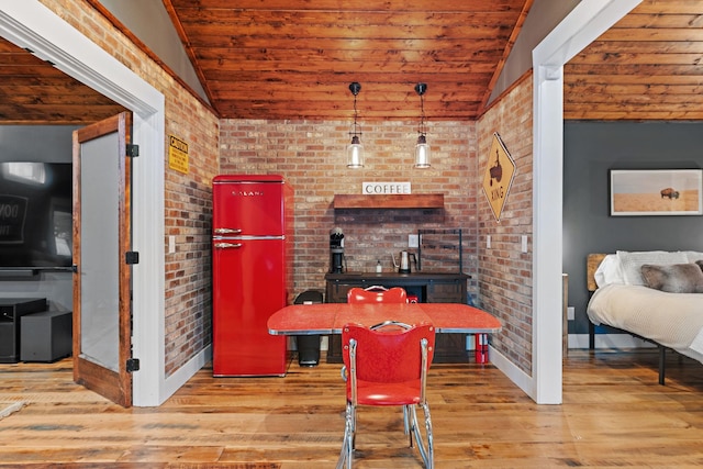 interior space with lofted ceiling, light hardwood / wood-style flooring, and brick wall