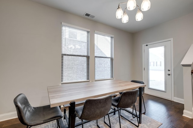 dining space featuring a notable chandelier, plenty of natural light, and dark hardwood / wood-style floors