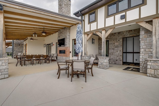 view of patio / terrace with ceiling fan and an outdoor fireplace