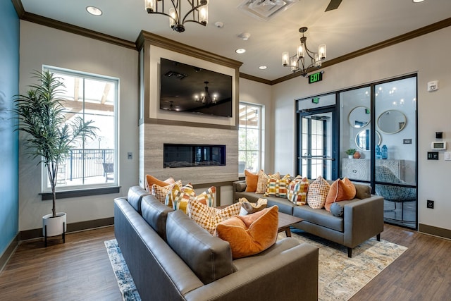 living room with crown molding, dark hardwood / wood-style floors, and a chandelier