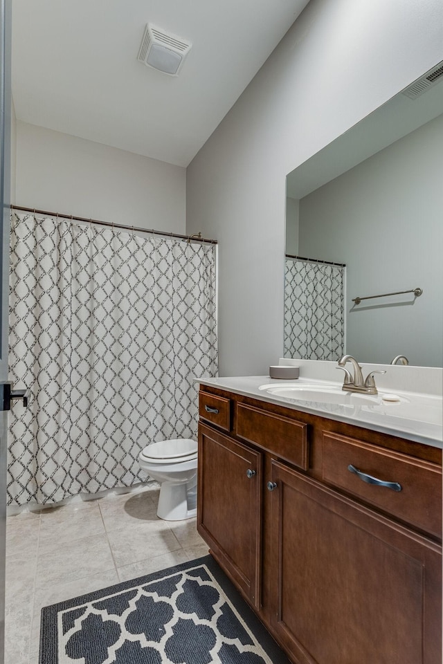 bathroom featuring vanity, tile patterned floors, and toilet