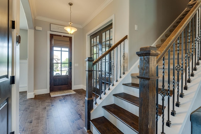 entryway with ornamental molding and dark hardwood / wood-style floors