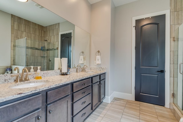 bathroom with tile patterned floors, a shower with door, and vanity